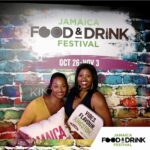 two women taking photo with Jamaica Food Festival background