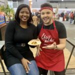 woman posing with chef in red apron